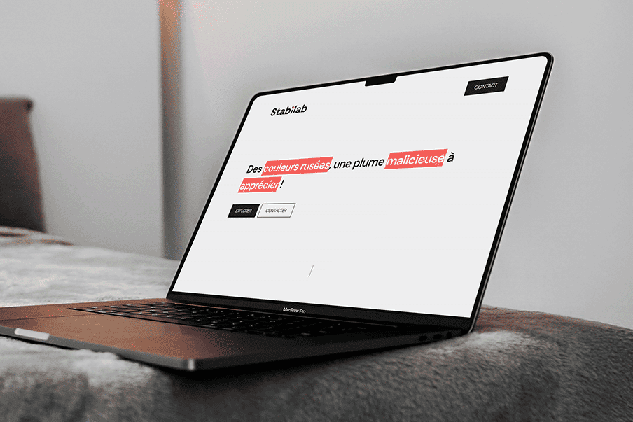Présentation du site sur McBook Pro posé sur un lit.